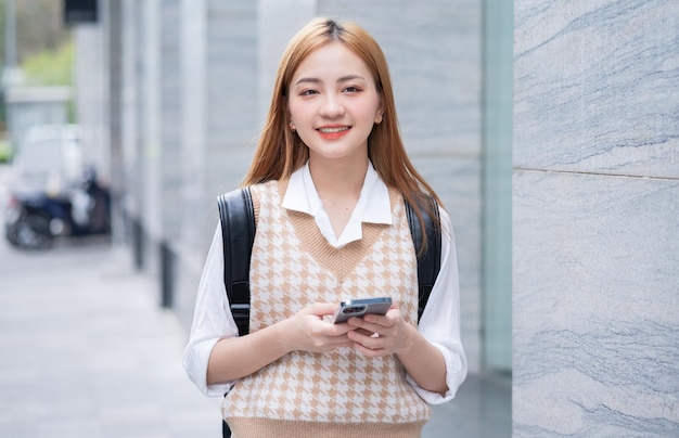 Young Asian woman using smartphone on street