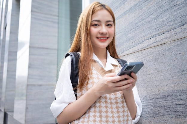 Young Asian woman using smartphone on street