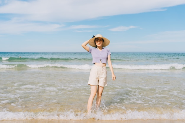 Young Asian woman walking on tropical beach