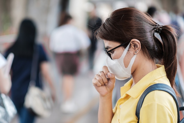 Young Asian woman wearing protection mask against Novel coronavirus (2019-nCoV) or Wuhan coronavirus at public train station,is a contagious virus that causes respiratory infection.Healthcare concept