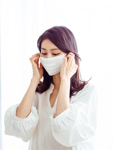 Young asian woman wearing Surgical mask to prevent infection at home quarantine