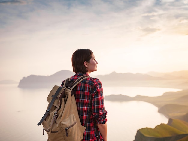 A young Asian woman with a backpack hiking in the summer