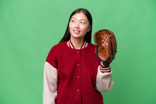 Young asian woman with baseball glove over isolated background thinking an idea while looking up