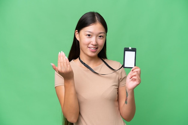 Young Asian woman with ID card over isolated background inviting to come with hand Happy that you came