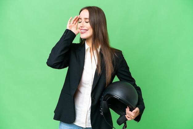 Young Asian woman with a motorcycle helmet over isolated chroma key background smiling a lot