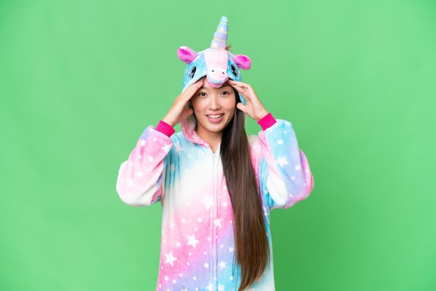 Young Asian woman with unicorn pajamas over isolated chroma key background with surprise expression