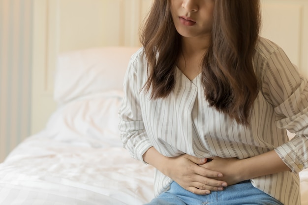 Young Asian women have severe stomachache. Health and sick people concept.