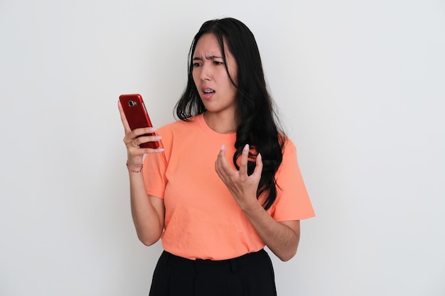 Young Asian women looking to her handphone and showing angry expression