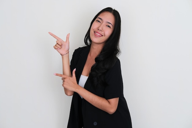 Young Asian women smiling to camera while pointing to the right side