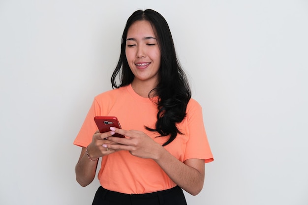 Young Asian women smiling while typing on his handphone