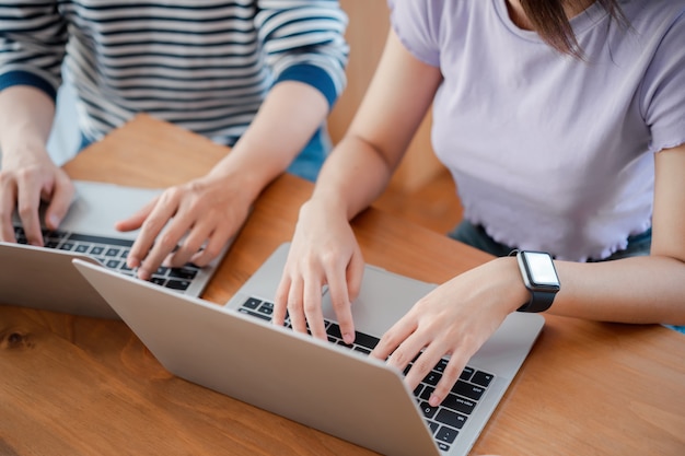 Young Asian worker discussing together and typing on computer during working day in home office