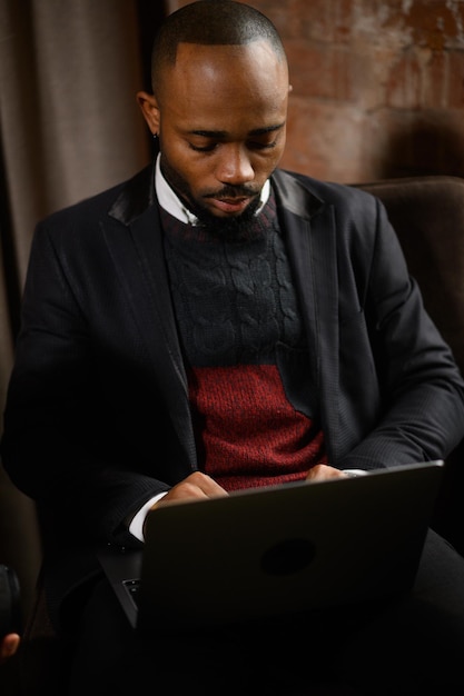 A young aspiring africanamerican investor works at a computer analyzes the securities market