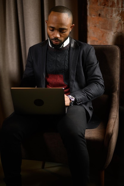 A young aspiring africanamerican investor works at a computer analyzes the securities market