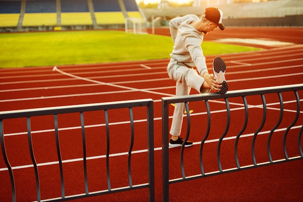 Young athlete doing stretching before running at the stadium High quality photo