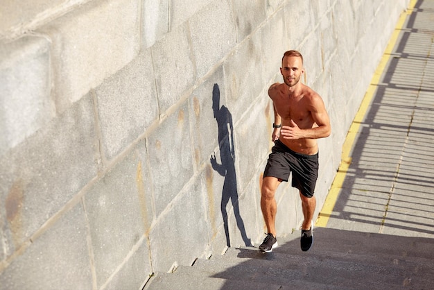 Young athlete man do morning run Male runs up the stairs doing cardio exercises