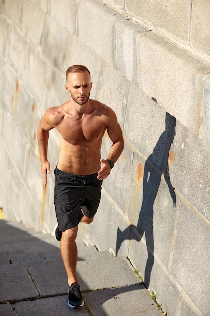 Young athlete man do morning run Male runs up the stairs doing cardio exercises