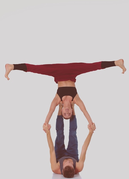 Young athletic couple practicing acroyoga Balancing in pair