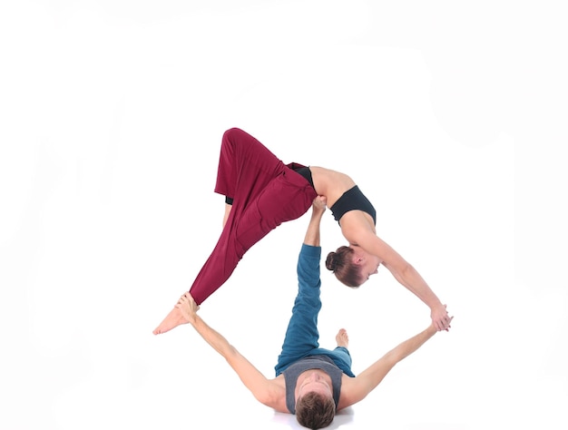 Young athletic couple practicing acroyoga balancing in pair