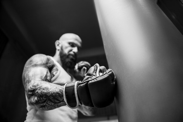 Young athletic man pumping up muscles in the gym at workout Sport and health care concept