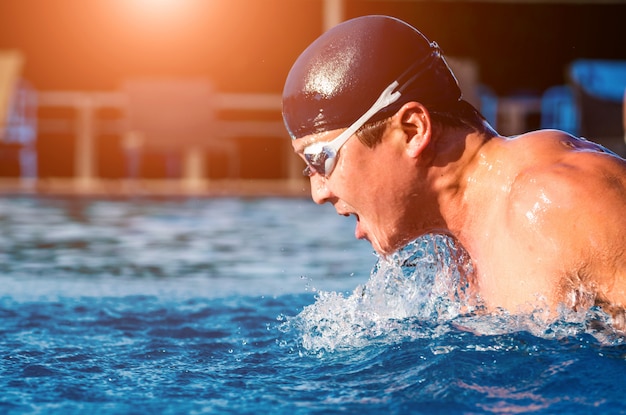 Young athletic man swimming in the swimming pool