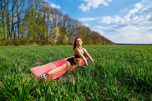 Young athletic woman doing longitudinal splits outdoors. Girl go in for sports, healthy lifestyle, athletic body. She is in sportswear, black top and shorts. Sport concept.