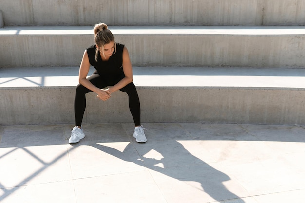 Young athletic woman and her shadow. Summer workout or concept of fighting yourself.