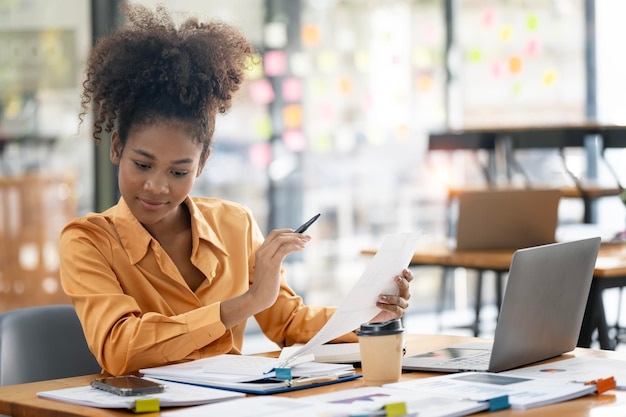 Young Attractive african american business woman analyzing stock market trader and research solutions for investation at office