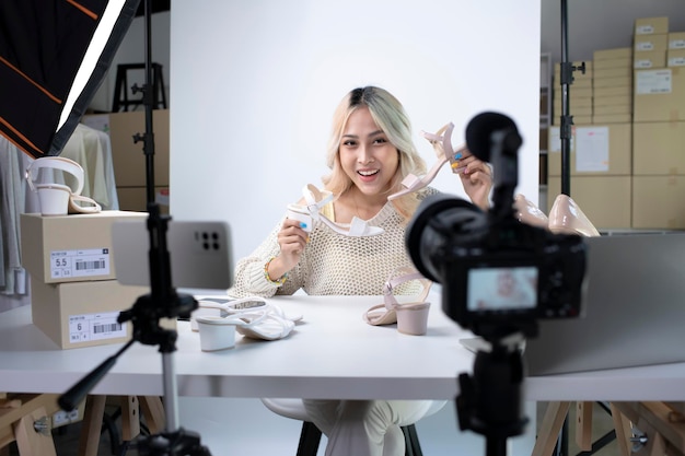 Young attractive Asian female blogger or vlogger looking at camera reviewing product Modern businesswoman using social media for marketing Business online influencer on social media concept