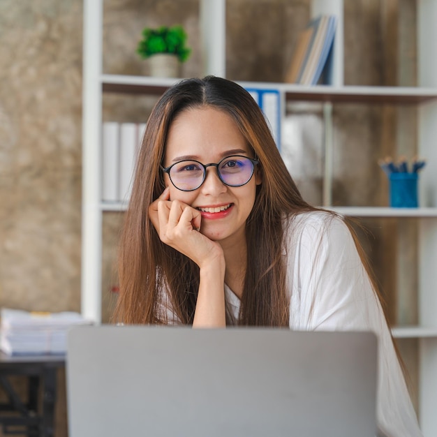 Young attractive asian female employee learning digital online course development program Looking camera