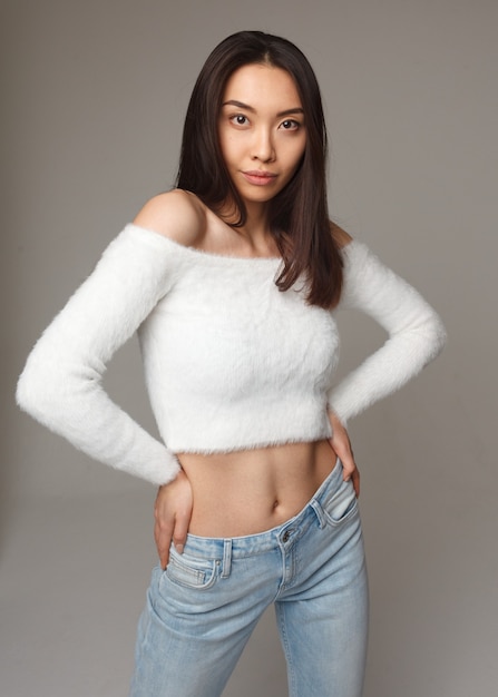 Young attractive asian woman in elegance pose on gray background