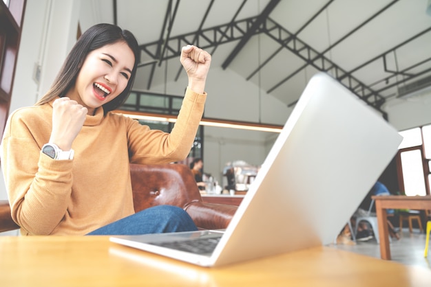 Young attractive asian woman looking at laptop computer