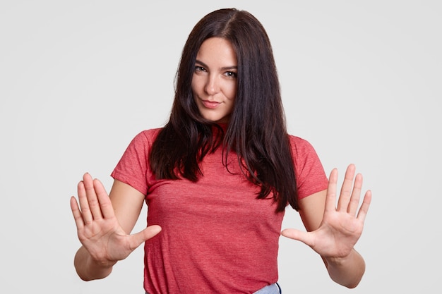 Young attractive brunette female makes stop gesture