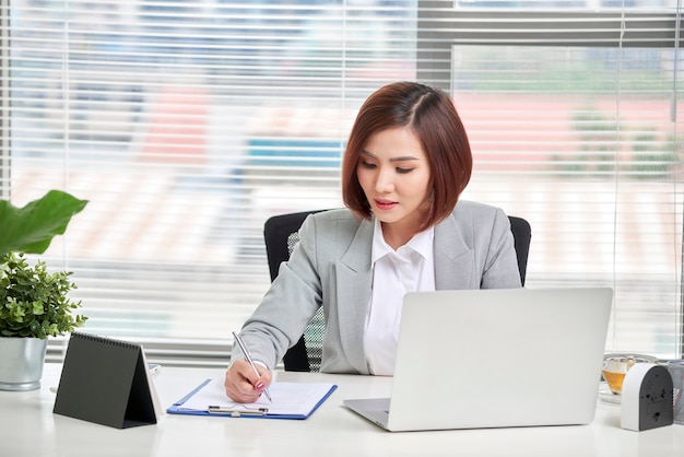 Young, attractive and confident business woman working in office