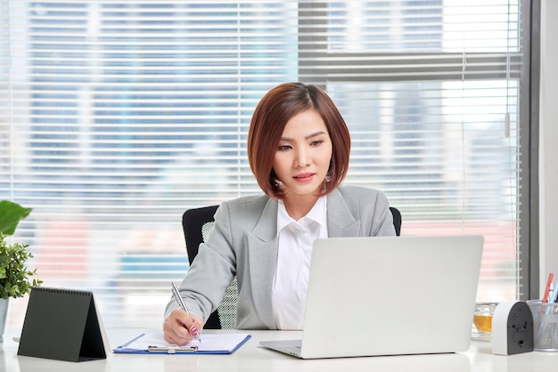 Young, attractive and confident business woman working in office