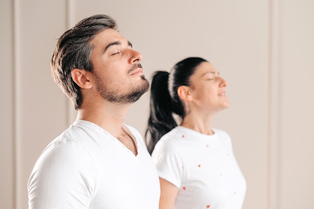 Young and attractive couple respiring and meditating with closed eyes Morning rituals