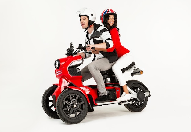 Young attractive couple riding an electric motorbike scooter happy having fun together