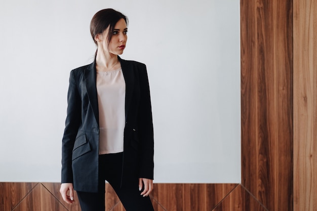 Young attractive emotional girl in business-style clothes 