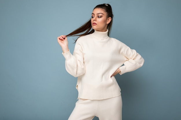 Young attractive european fashion woman wearing white sweater isolated over blue