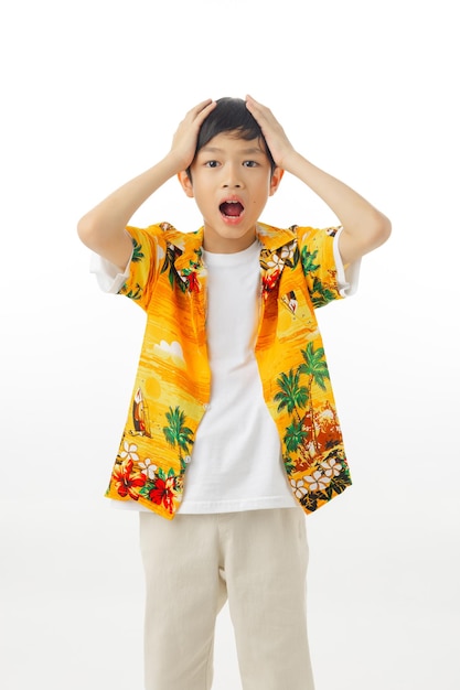 Young attractive excited Asian boy hold water gun in in Hawaiian shirts on white background with clipping path Songkran Thailand