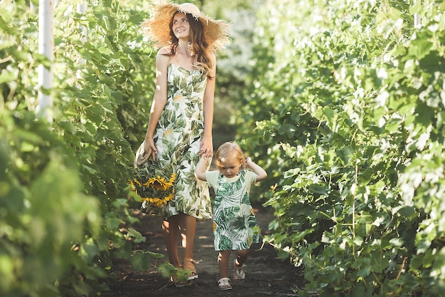 Young attractive mother and her little baby girl outdoors.