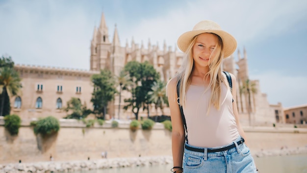 Young attractive smiling girl tourist exploring new city at summer