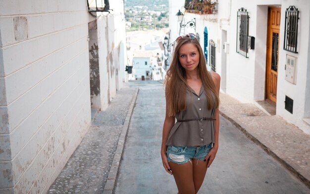 Young attractive smiling girl tourist in hat exploring new Europe city at summer holiday