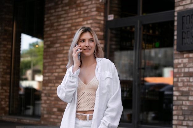 Young attractive smiling happily talking on a smartphone on a city street