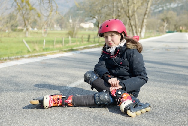 Young attractive teenage skater grimacing in pain after taking a fall