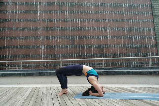 Young attractive woman doing stretching yoga exercise in the park