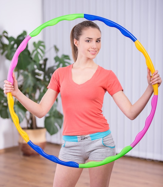 Young attractive woman holding hula hoop.