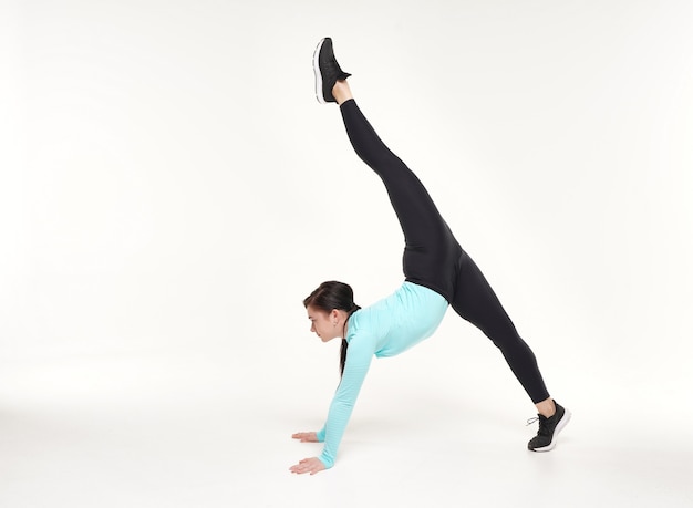 Young attractive woman making yoga and gymnastics stretching exercises isolated on white background