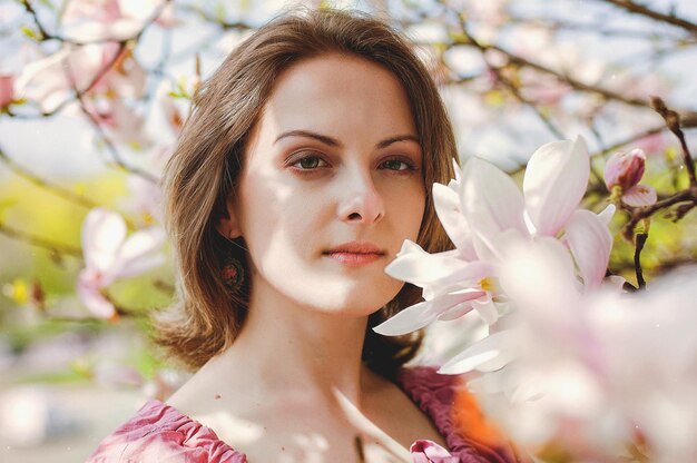 young attractive woman in spring garden. blooming magnolias. Spring background. Lifestyle portrait