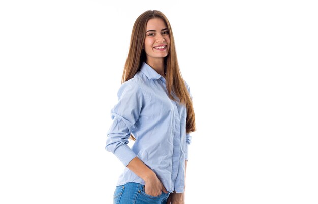 Young attractive woman with long brown hair wearing a blue shirt on white background in studio