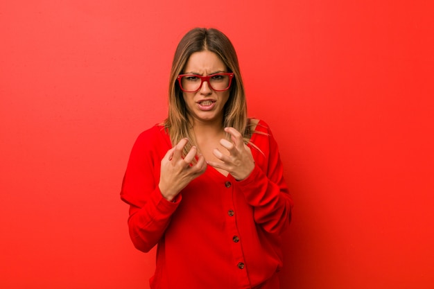 Young authentic charismatic real people woman on wall upset screaming with tense hands.